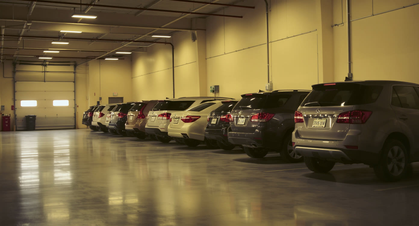 Row of vehicles waiting in a dealership service bay